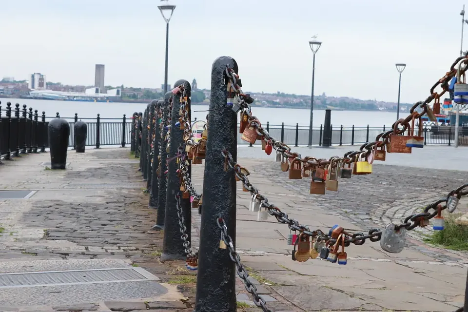 Padlocks fastened to iron chains along a waterfront promenade